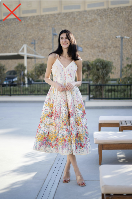 A petite woman wearing a non-flattering midi dress.