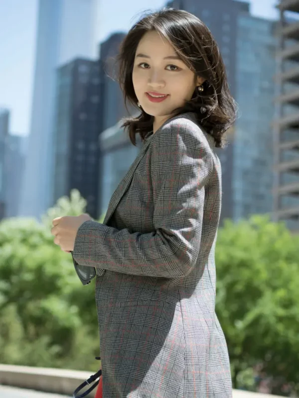 Petite woman wearing a tailored gray plaid blazer, outdoor city backdrop, stylish fit ideal for petite frames