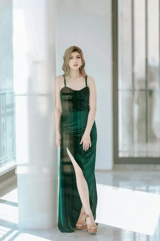 A petite woman in a fashionable green maxi dress.