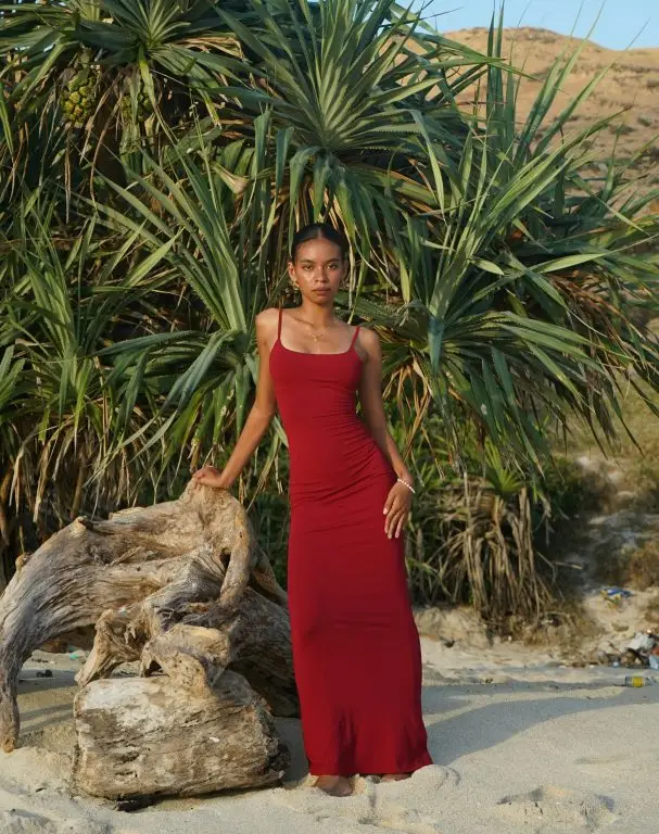 A petite woman in a fashionable red maxi dress.
